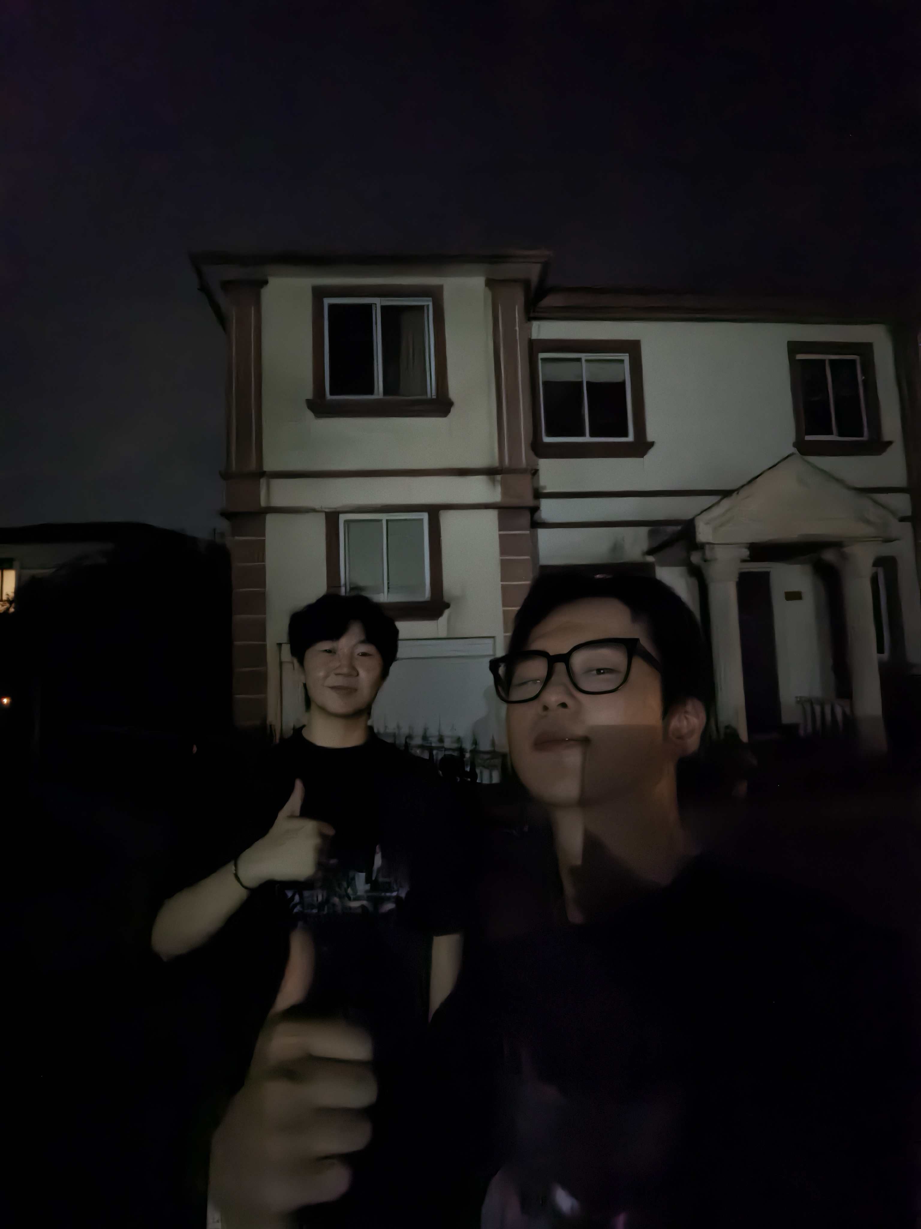 Two people standing outside a house at night